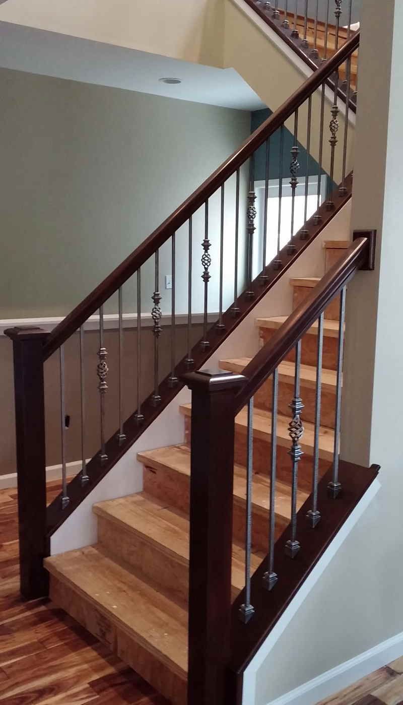 Wooden staircase with dark railings and white walls in a home interior