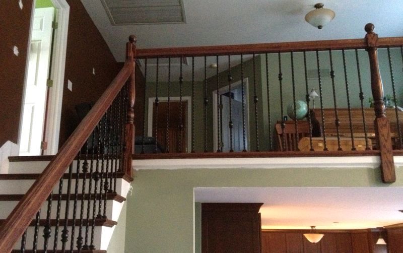 Interior view of a home with a staircase, loft railing, and dining area below.