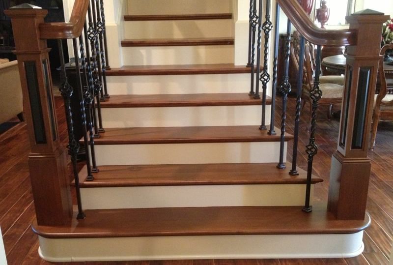 Wooden staircase with dark iron railings and polished steps in a home interior