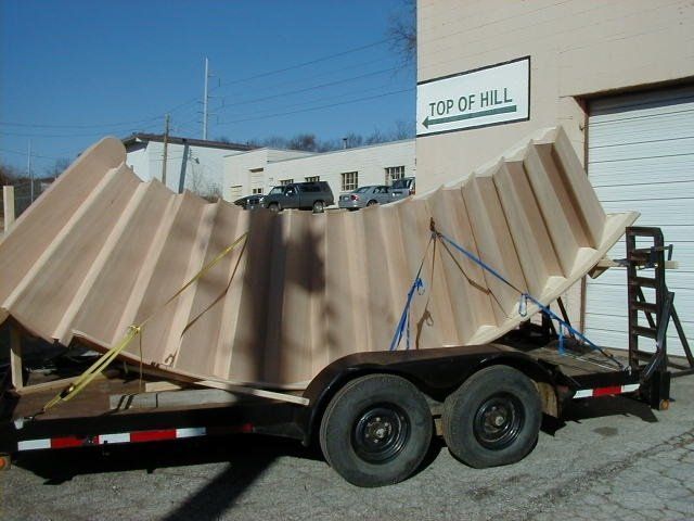 Crushed corrugated metal panel on a trailer in a parking lot with a 