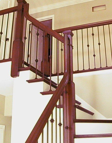 Wooden staircase with red banisters and beige walls in a home interior