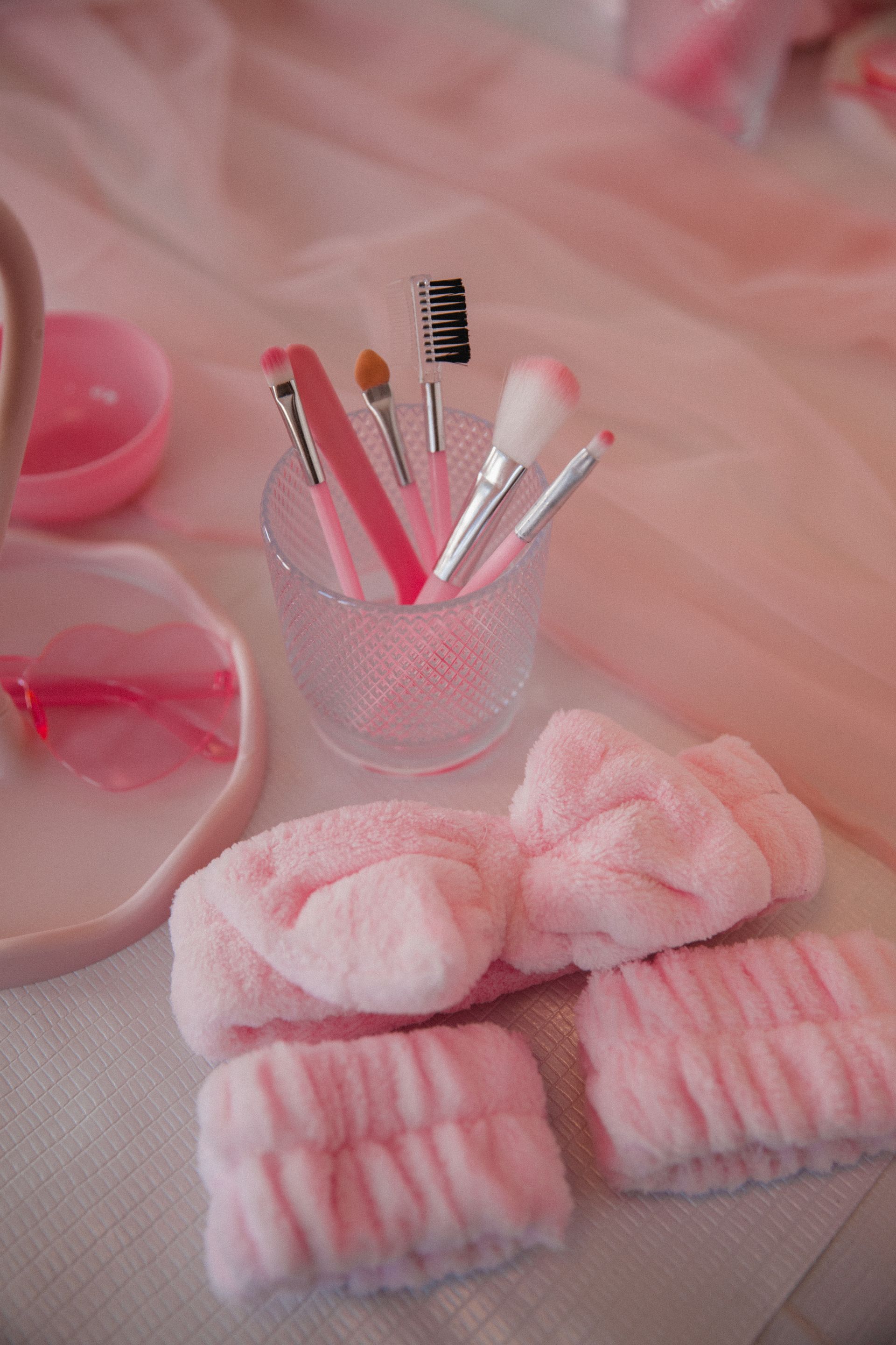 Auf einem Tisch liegen ein rosa Haarband und Bürsten.