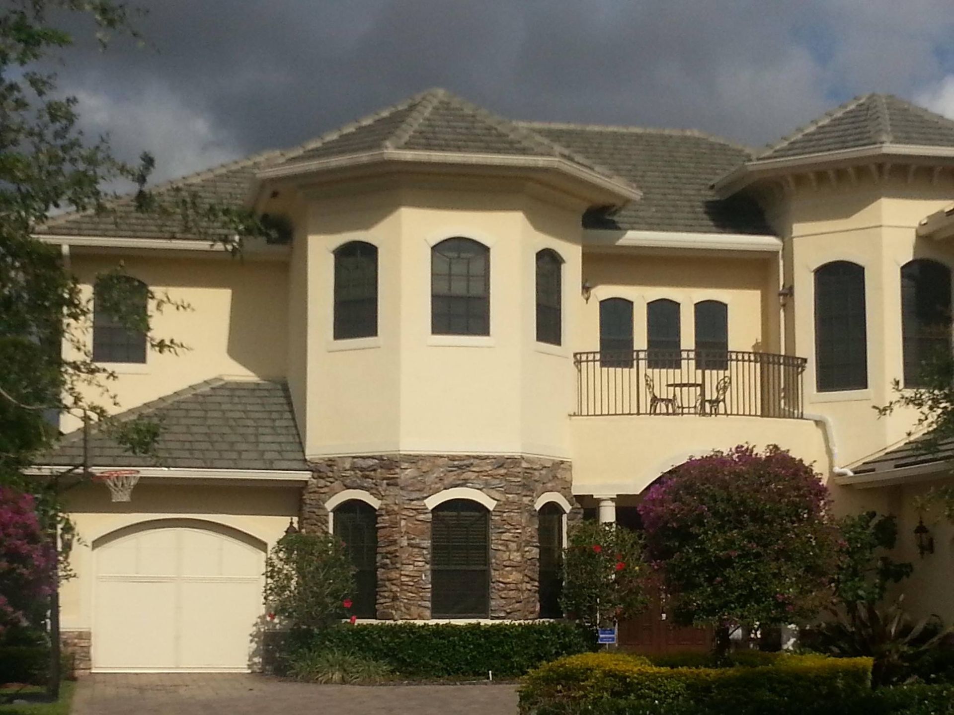 A large house with a white garage door and a balcony