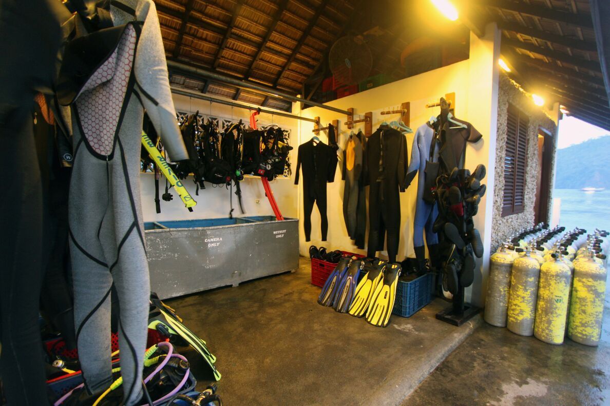 A room filled with scuba gear and scuba tanks.