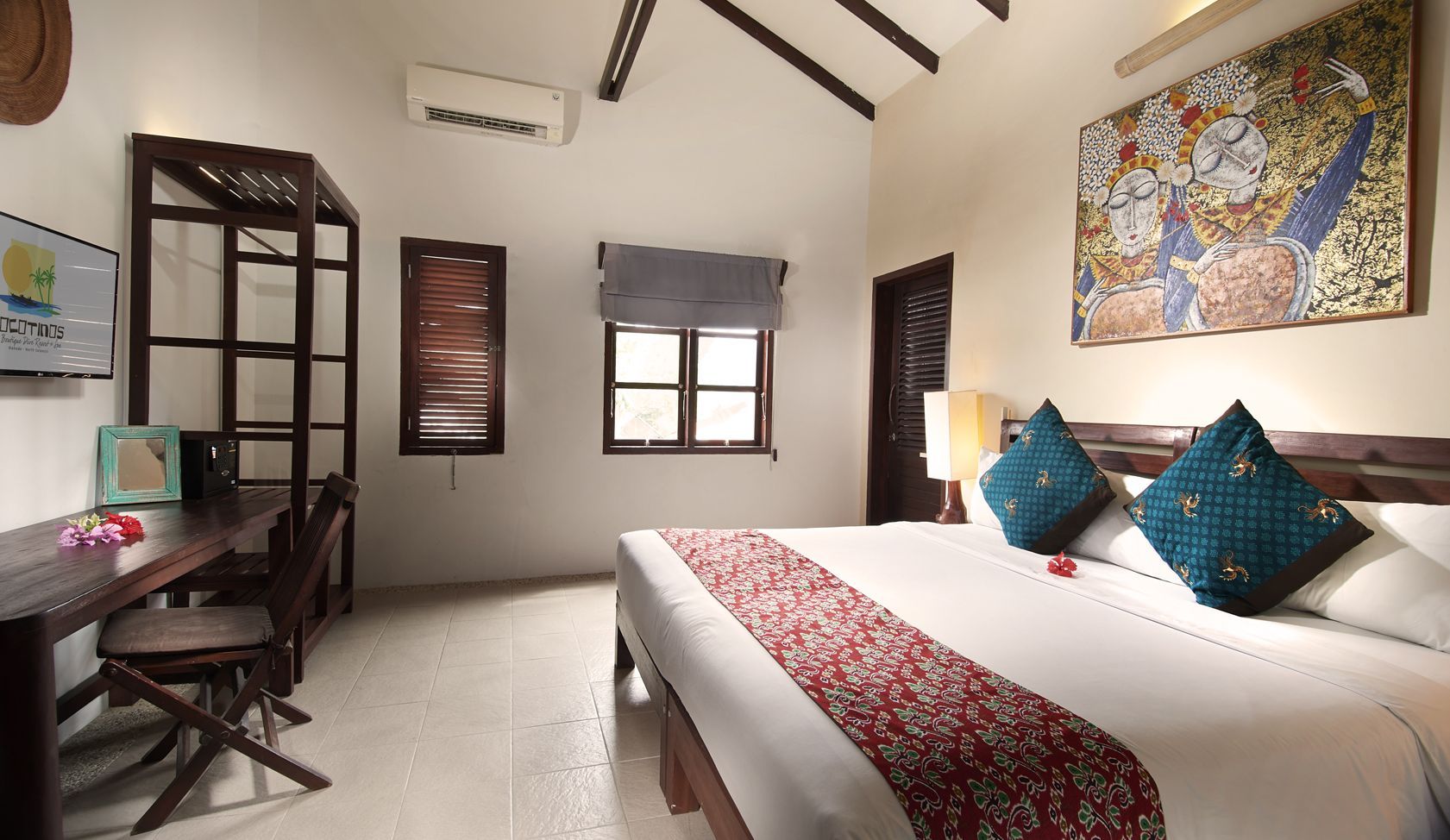 A hotel room with a king size bed and blue pillows