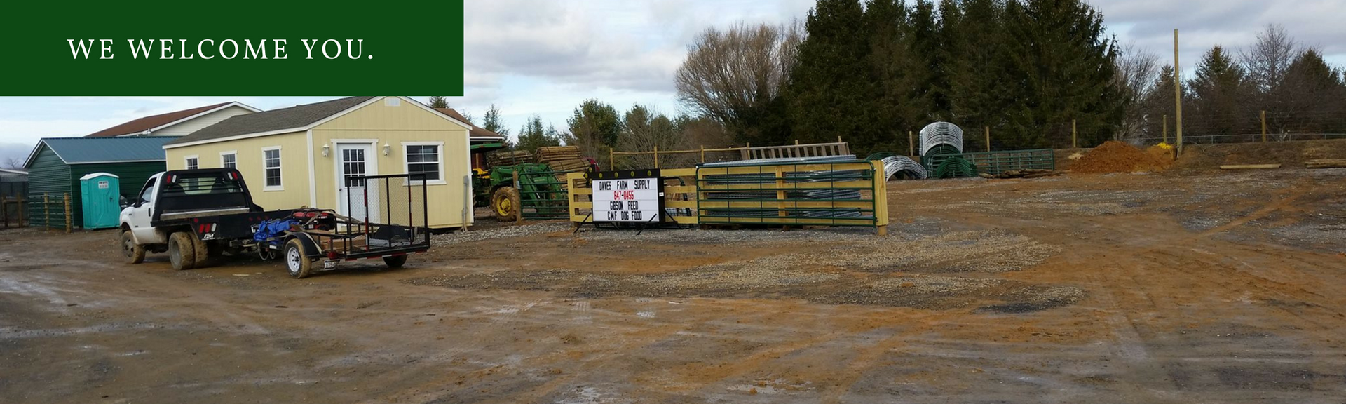 A truck is parked in front of a building that says we welcome you