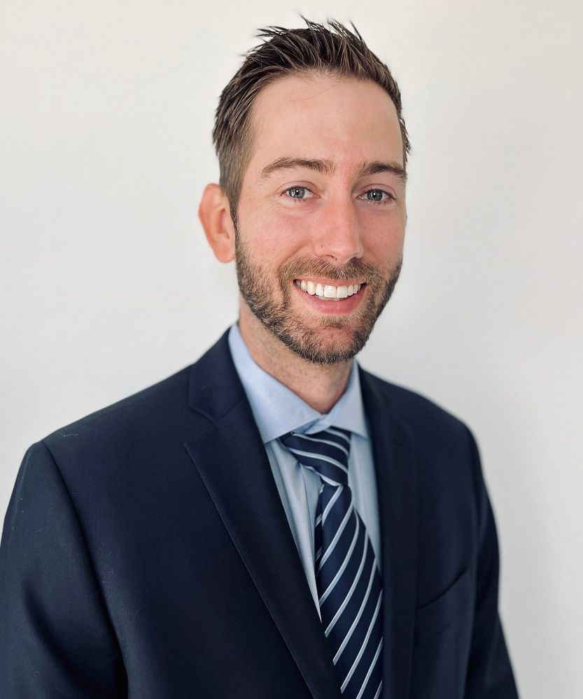 A man in a suit and tie is smiling for the camera.