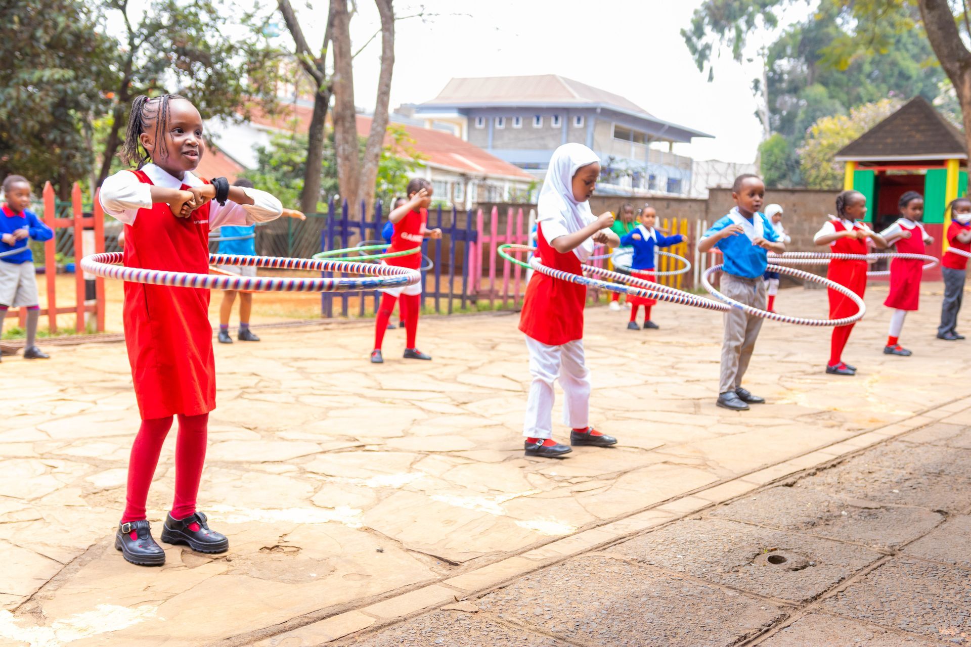 A group of children are playing with hula hoops in a playground.