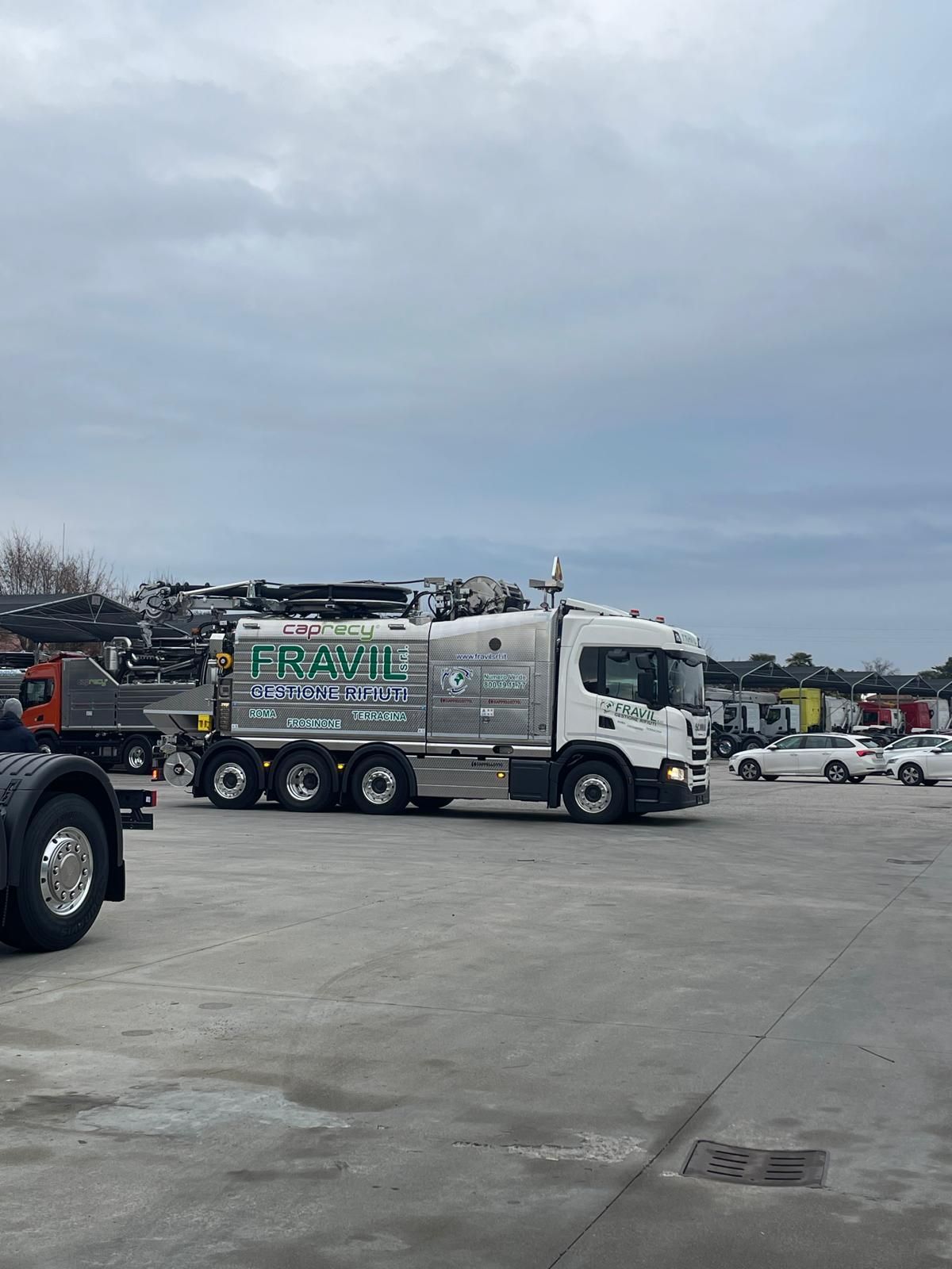 Camion bianco Fravil, parcheggiato su un piazzale in cemento, con cielo nuvoloso sullo sfondo.