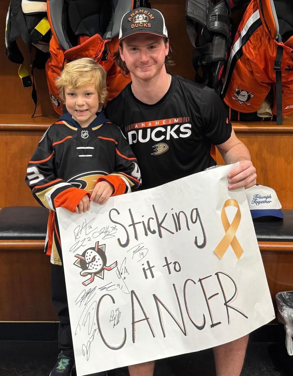Man and child holding a sign that says