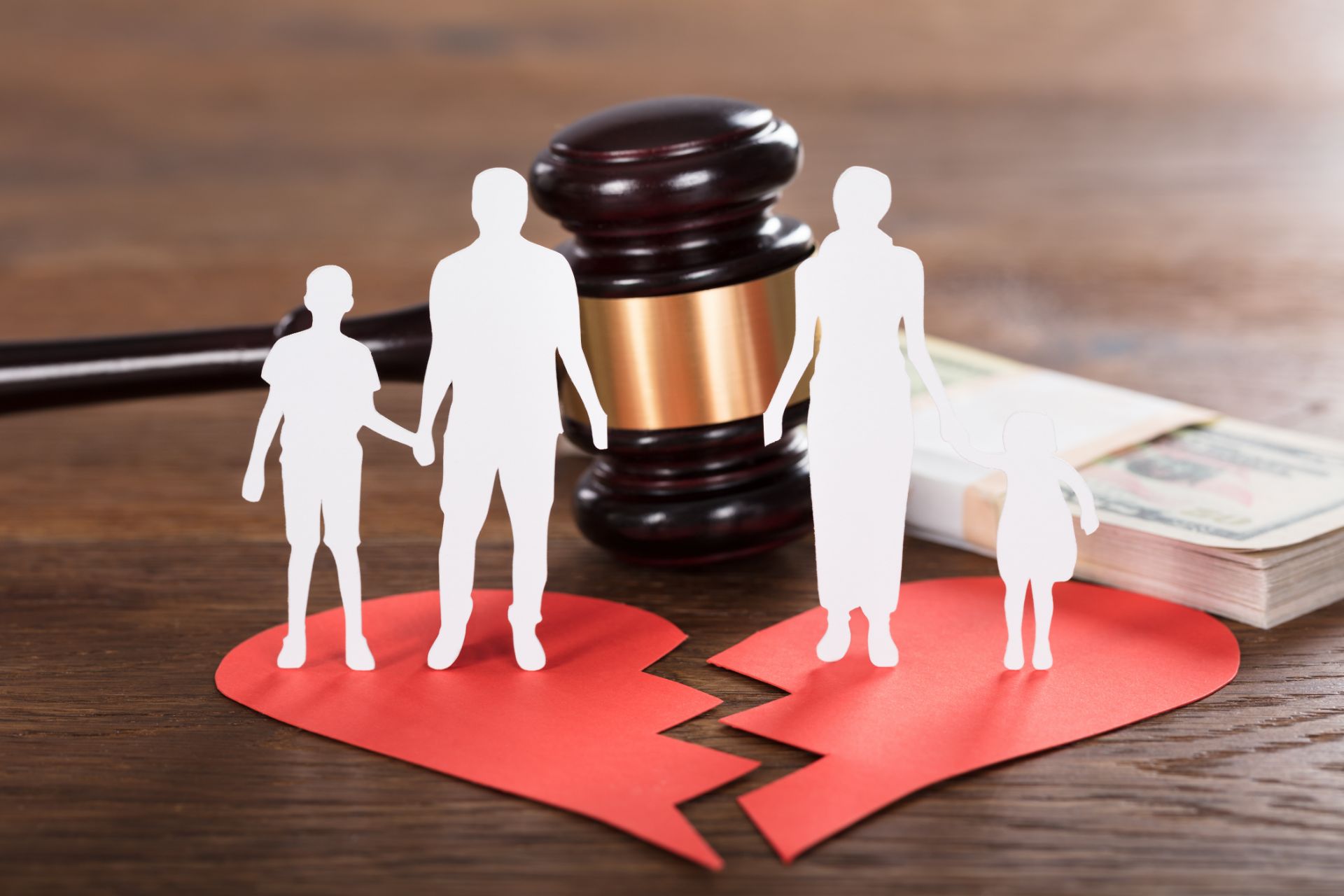 Cut out family standing on cut out broken heart