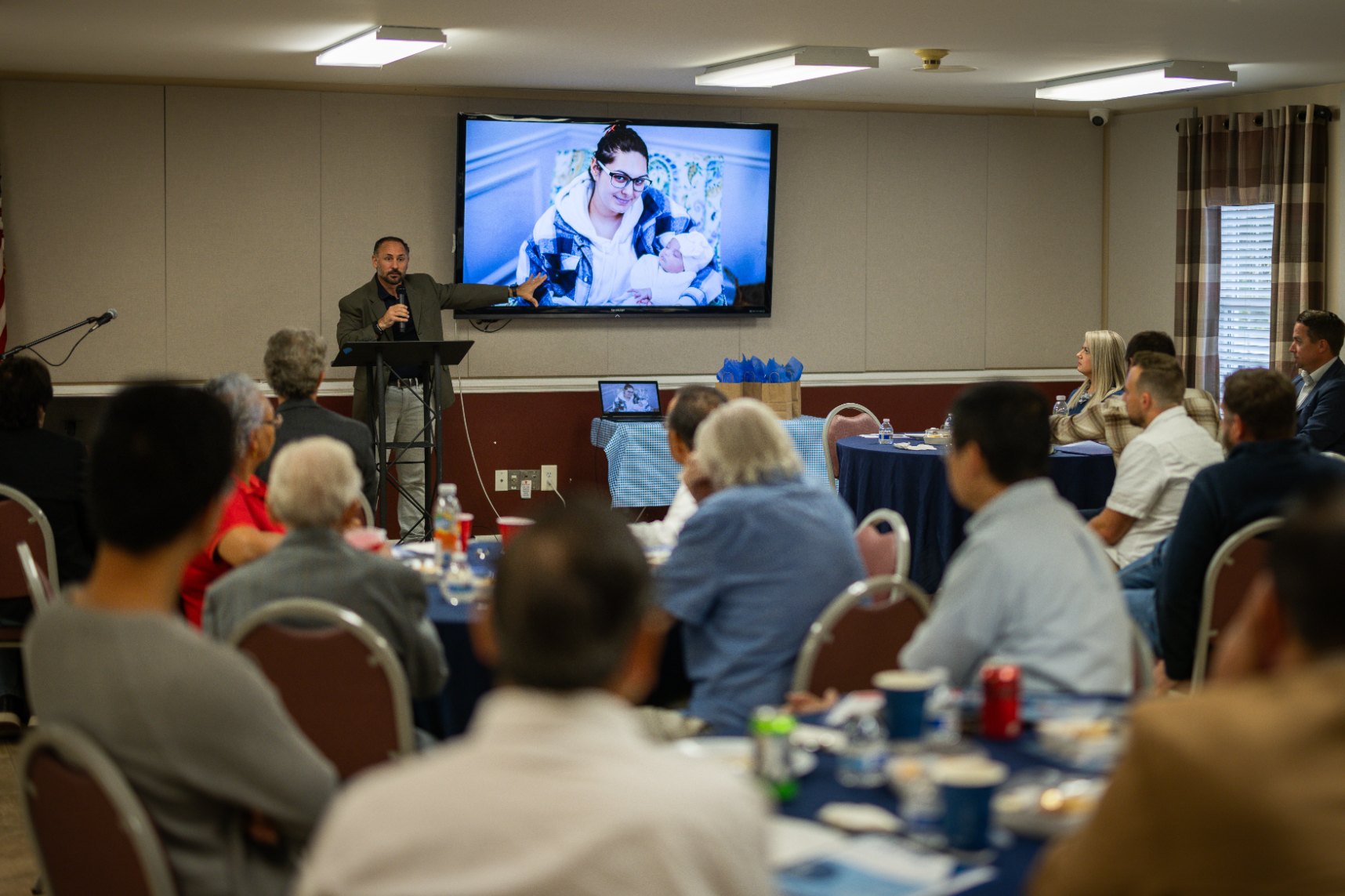 A man is giving a presentation to a group of people in a room.