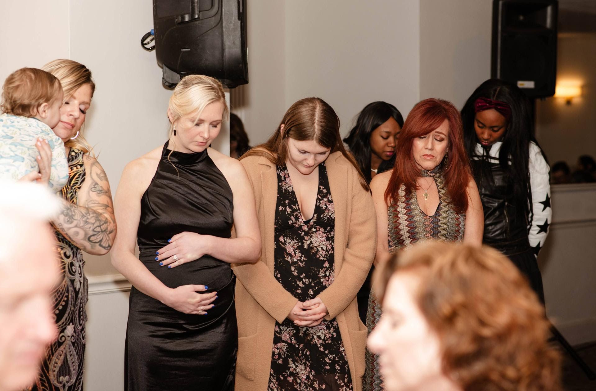 A group of women are standing next to each other in a room.