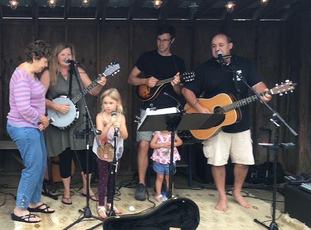 A group of people playing guitars and banjos on a stage
