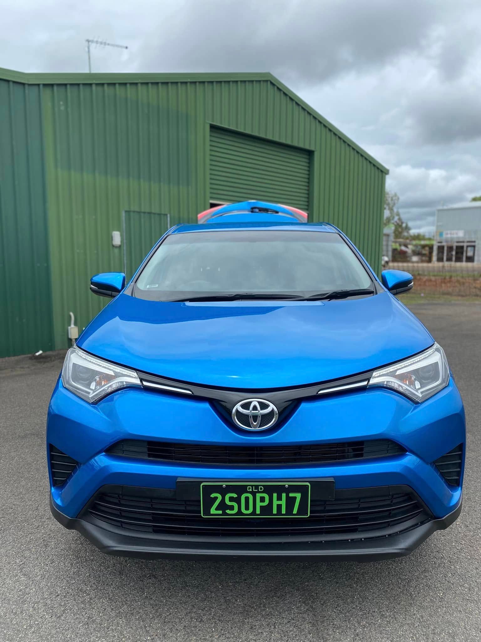 Front view of a bright blue Toyota SUV parked outside a green industrial building — Beclean Auto Detailing in Mareeba, QLD