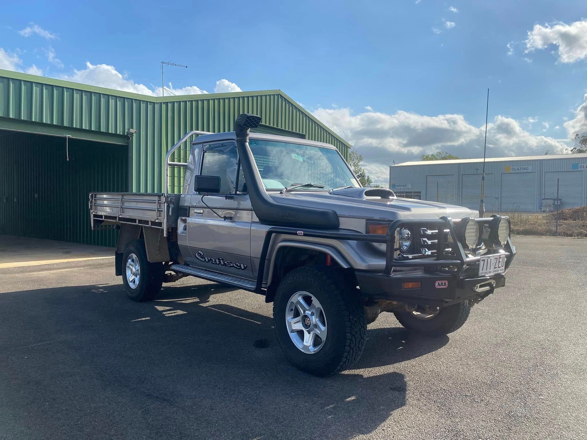 Black Pickup Truck Parked Outside a Green Metal Building on A Sunny Day — Beclean Auto Detailing in Mareeba, QLD