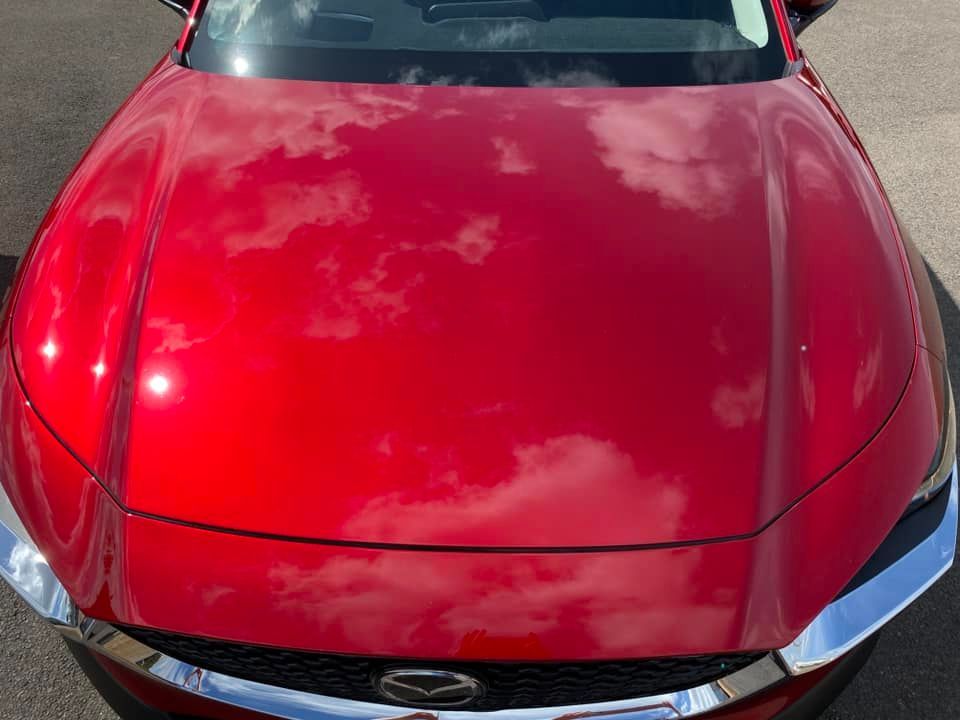Red car hood reflecting clouds, front view — Beclean Auto Detailing in Mareeba, QLD