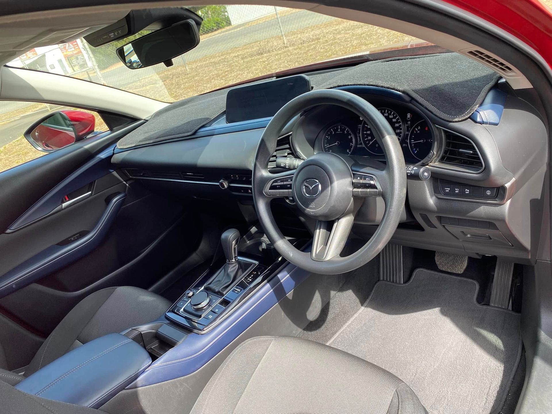 Sports car interior with right-hand steering wheel, black and blue seats, and center console view — Beclean Auto Detailing in Mareeba, QLD