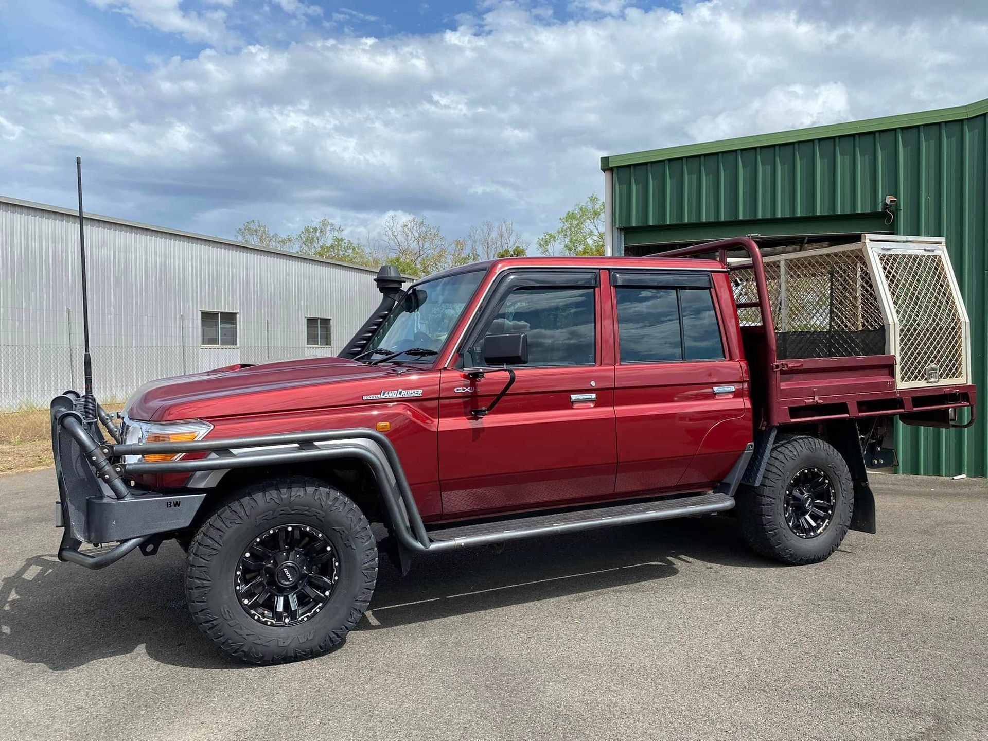 Red Toyota Land Cruiser Truck With a Flatbed, Black Wheels, and a Cage on the Back — Beclean Auto Detailing in Mareeba, QLD