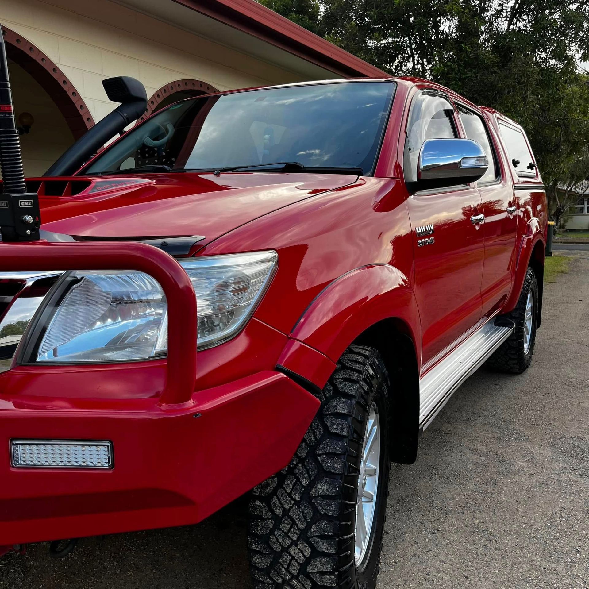 Red Toyota Hilux Truck With Off-road Modifications Parked in Front of a Building — Beclean Auto Detailing in Mareeba, QLD
