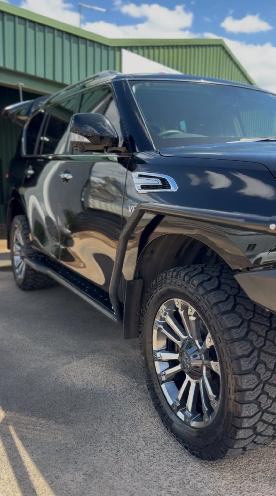 Black SUV with chrome rims and all-terrain tires parked in front of a green building — Beclean Auto Detailing in Mareeba, QLD