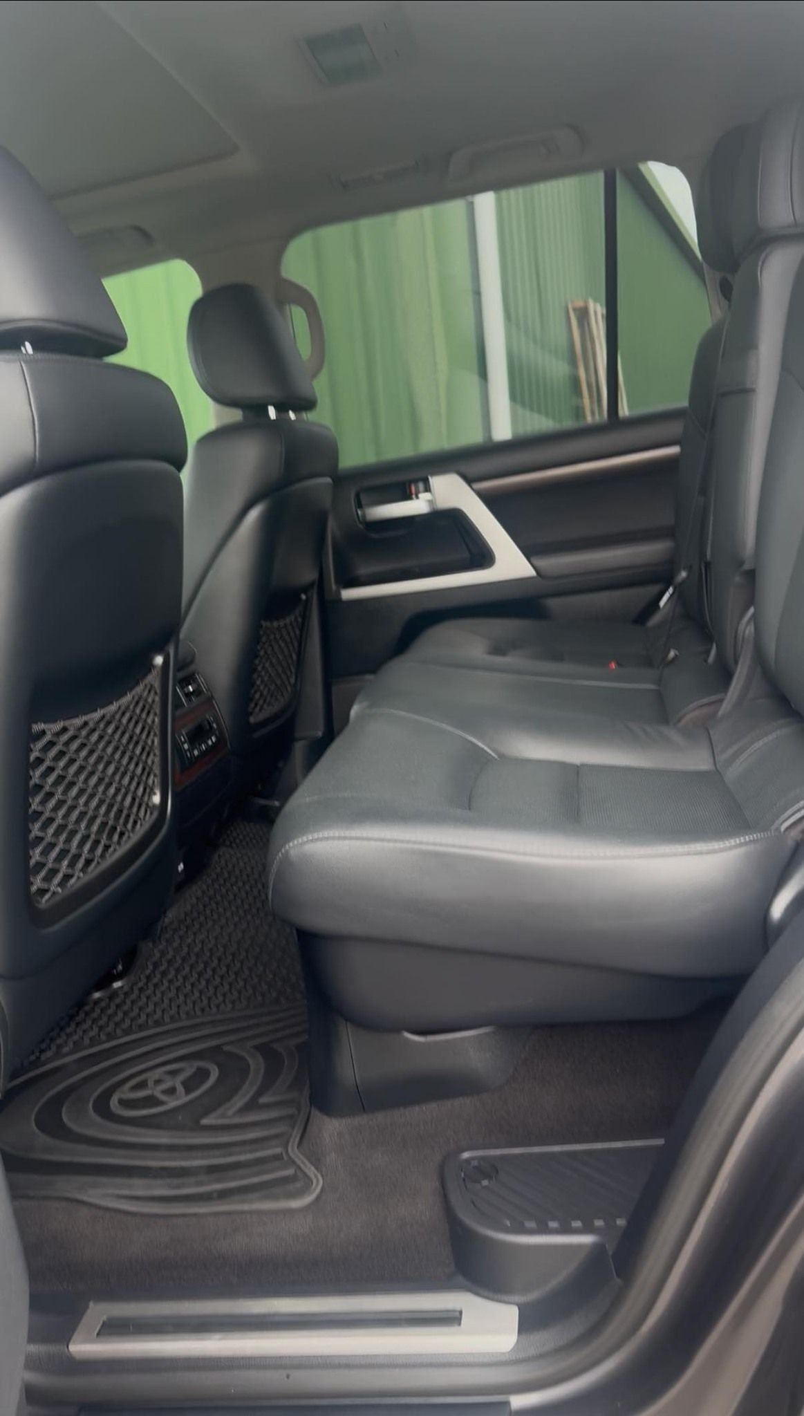 Back seat of a dark gray car interior with black leather seats and floor mats — Beclean Auto Detailing in Mareeba, QLD