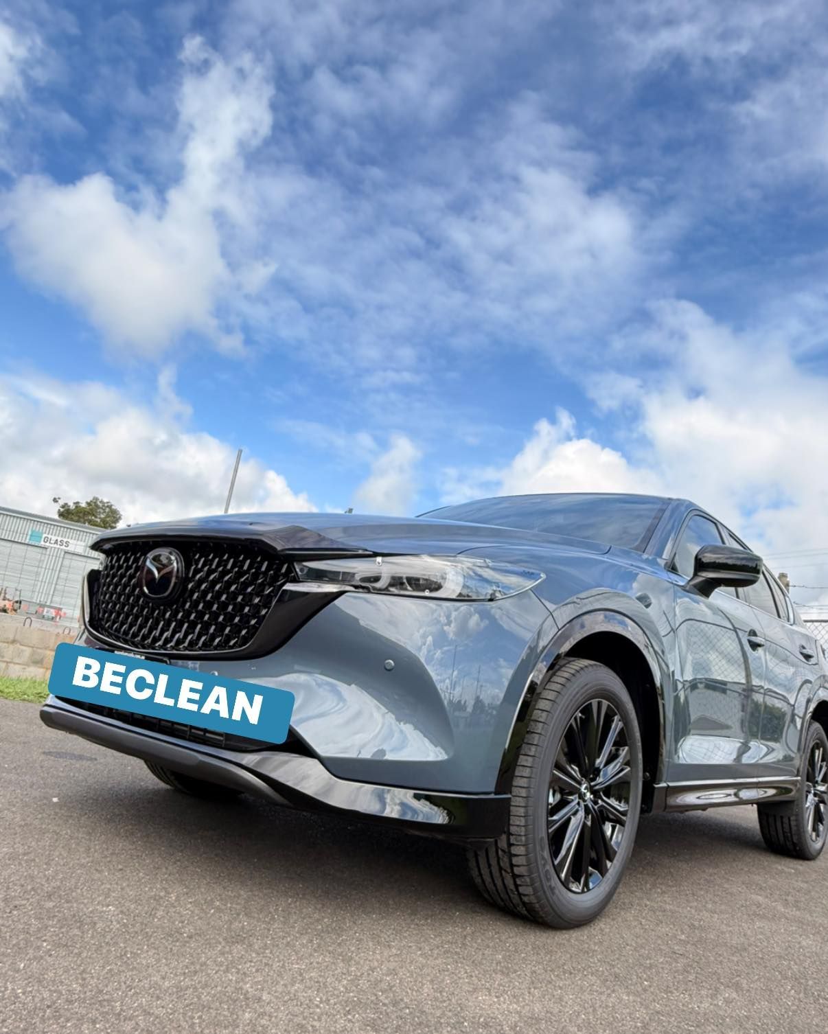 Dark gray Toyota SUV on pavement under a blue sky, with a “BECLEAN” plate on the front — Beclean Auto Detailing in Mareeba, QLD