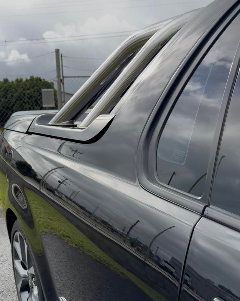 Shiny black car side with chrome trim and a partially open window, viewed close up outdoors — Beclean Auto Detailing in Mareeba, QLD