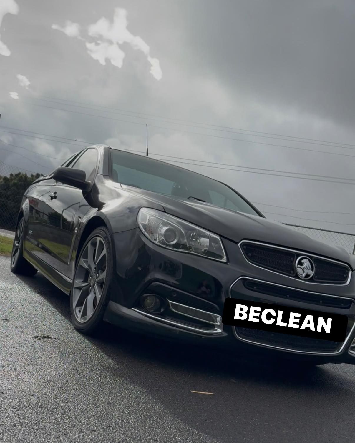 Black Vauxhall sedan on wet road under cloudy sky, front three-quarter view — Beclean Auto Detailing in Mareeba, QLD