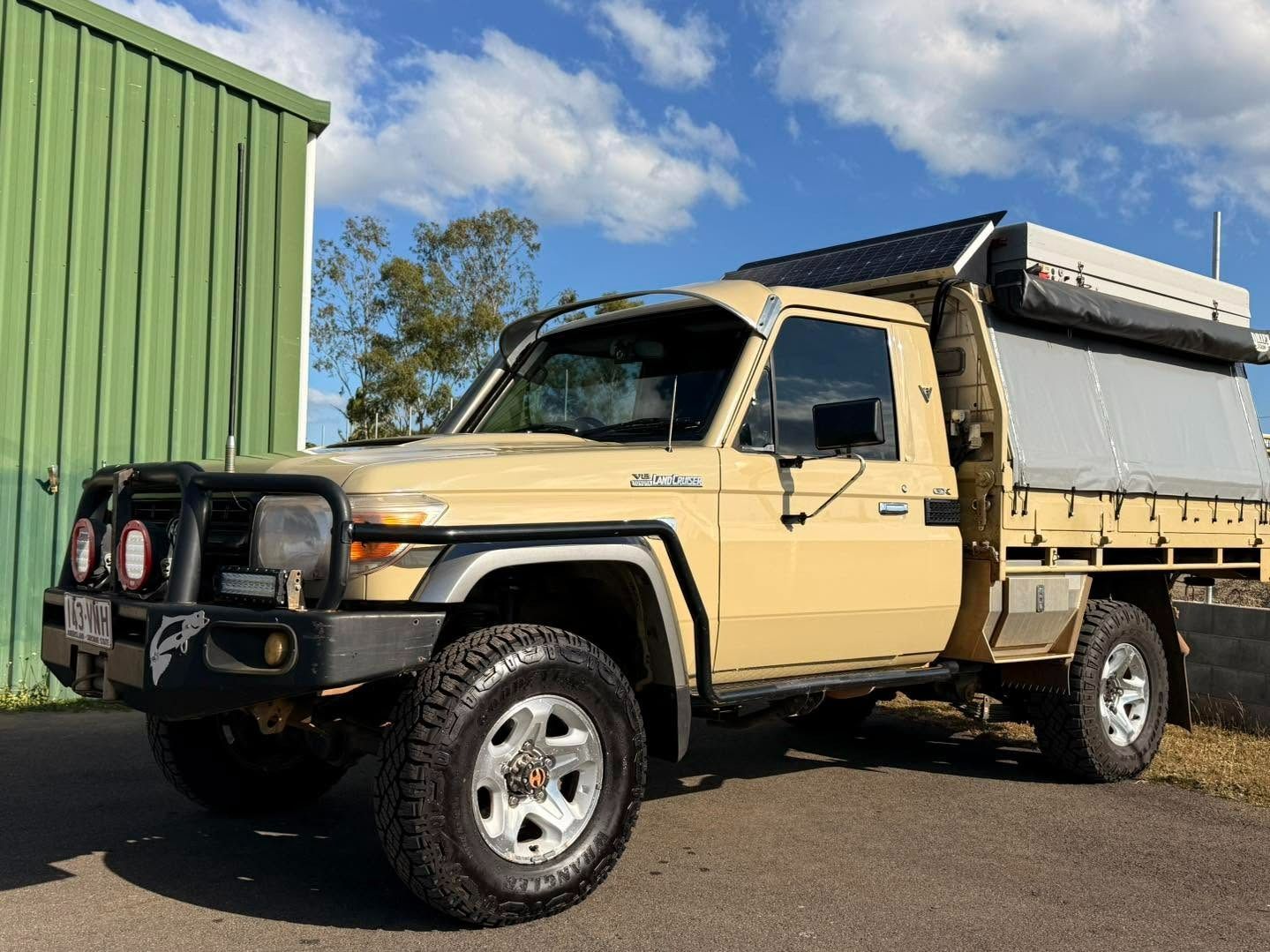Tan Toyota Land Cruiser Pickup Truck With a Camper Setup, Parked Outside — Beclean Auto Detailing in Mareeba, QLD