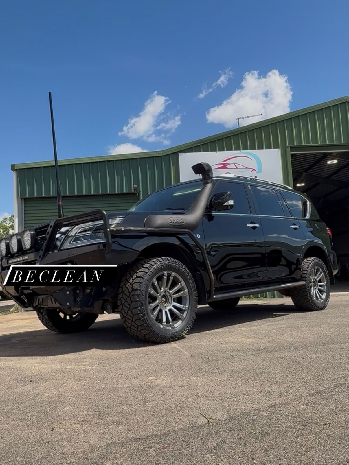 Black Off-road SUV Parked in Front of a Green Building on a Sunny Day — Beclean Auto Detailing in Mareeba, QLD