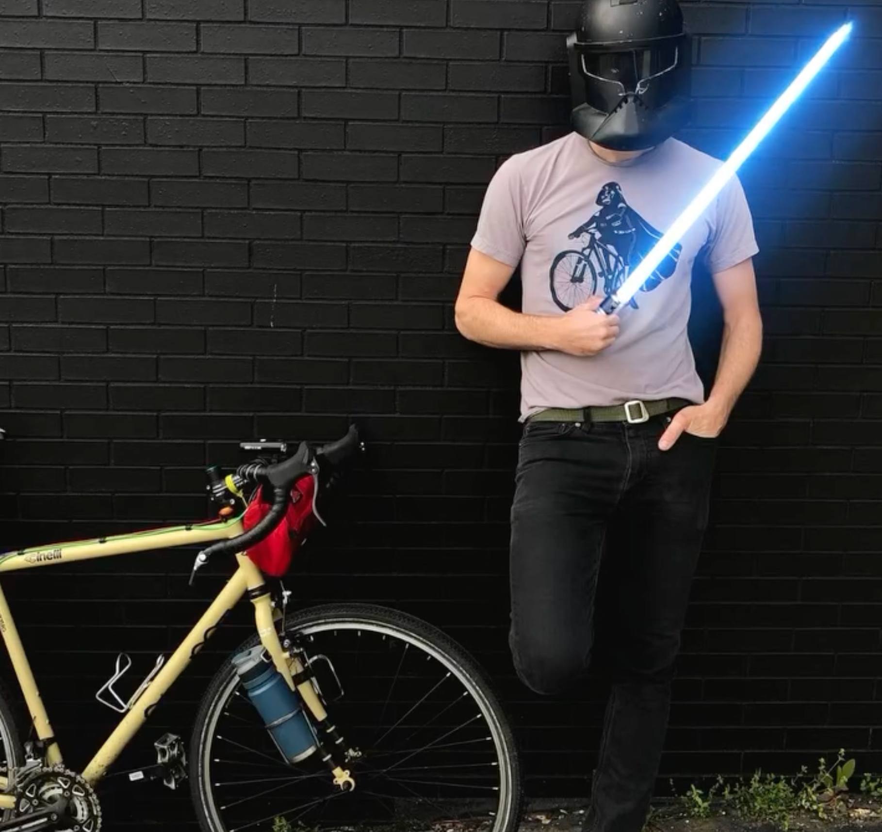 A man holding a light saber next to a bicycle