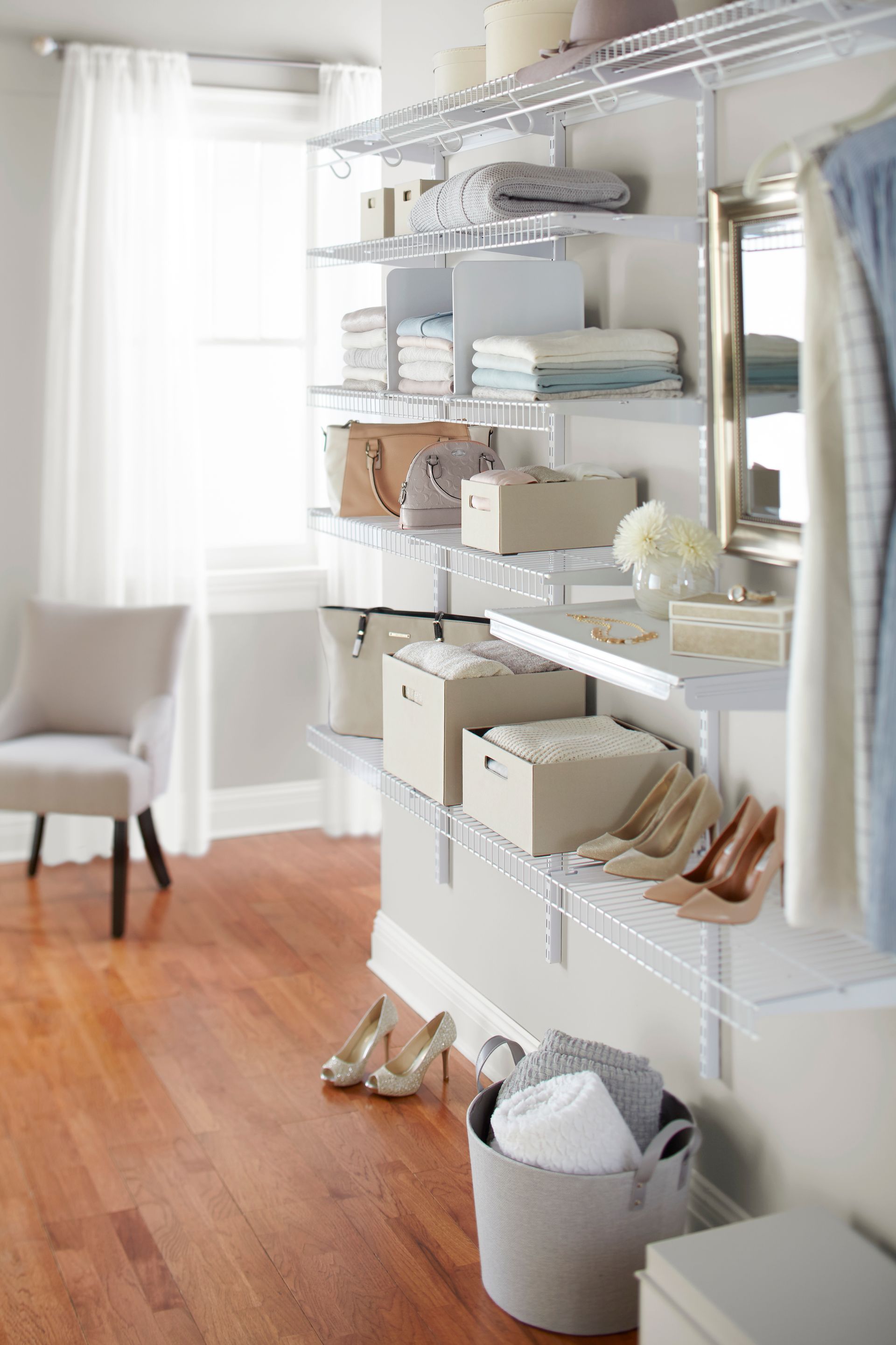 A walk in closet with lots of shelves and a chair.