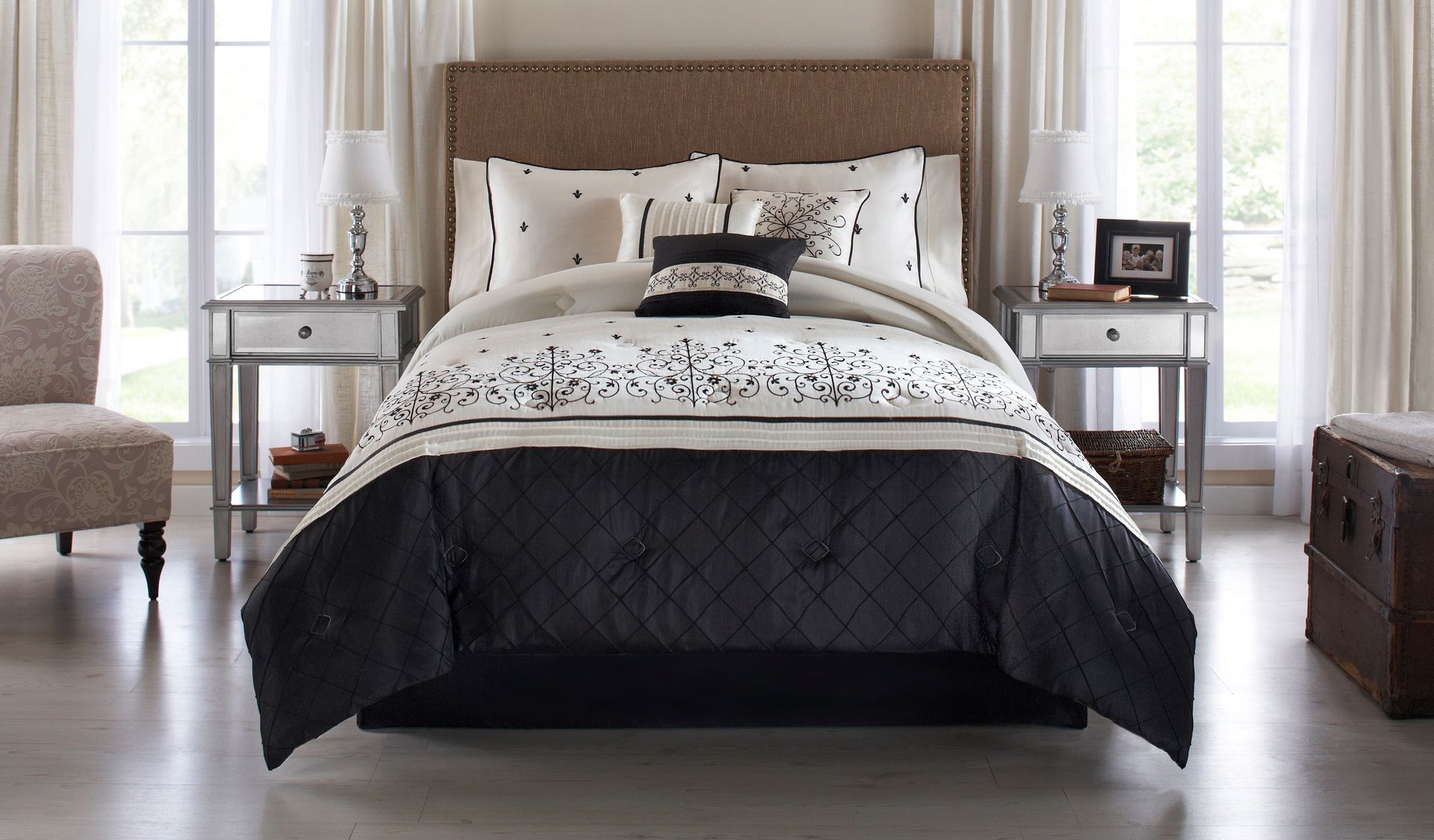 A bed with a black comforter and pillows in a bedroom