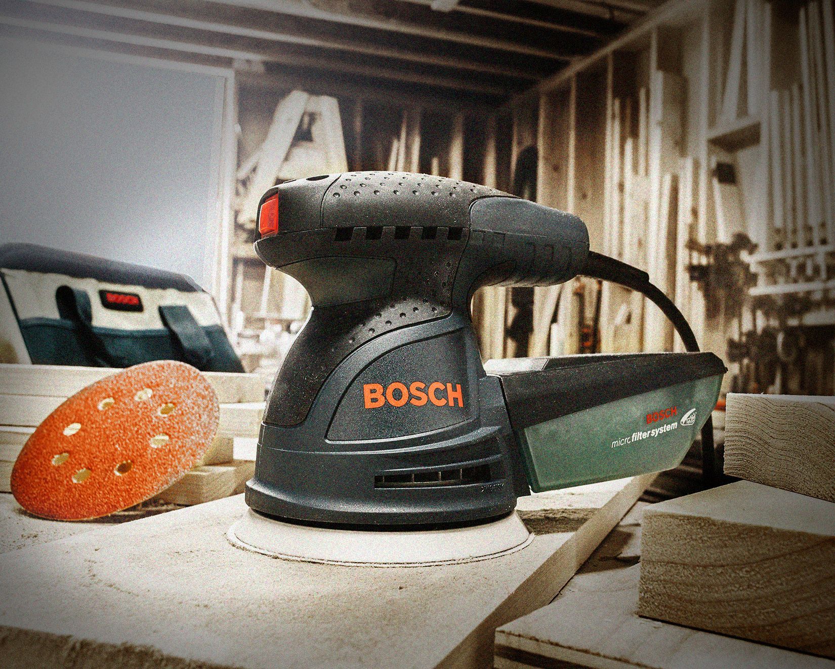 A bosch sander is sitting on a piece of wood