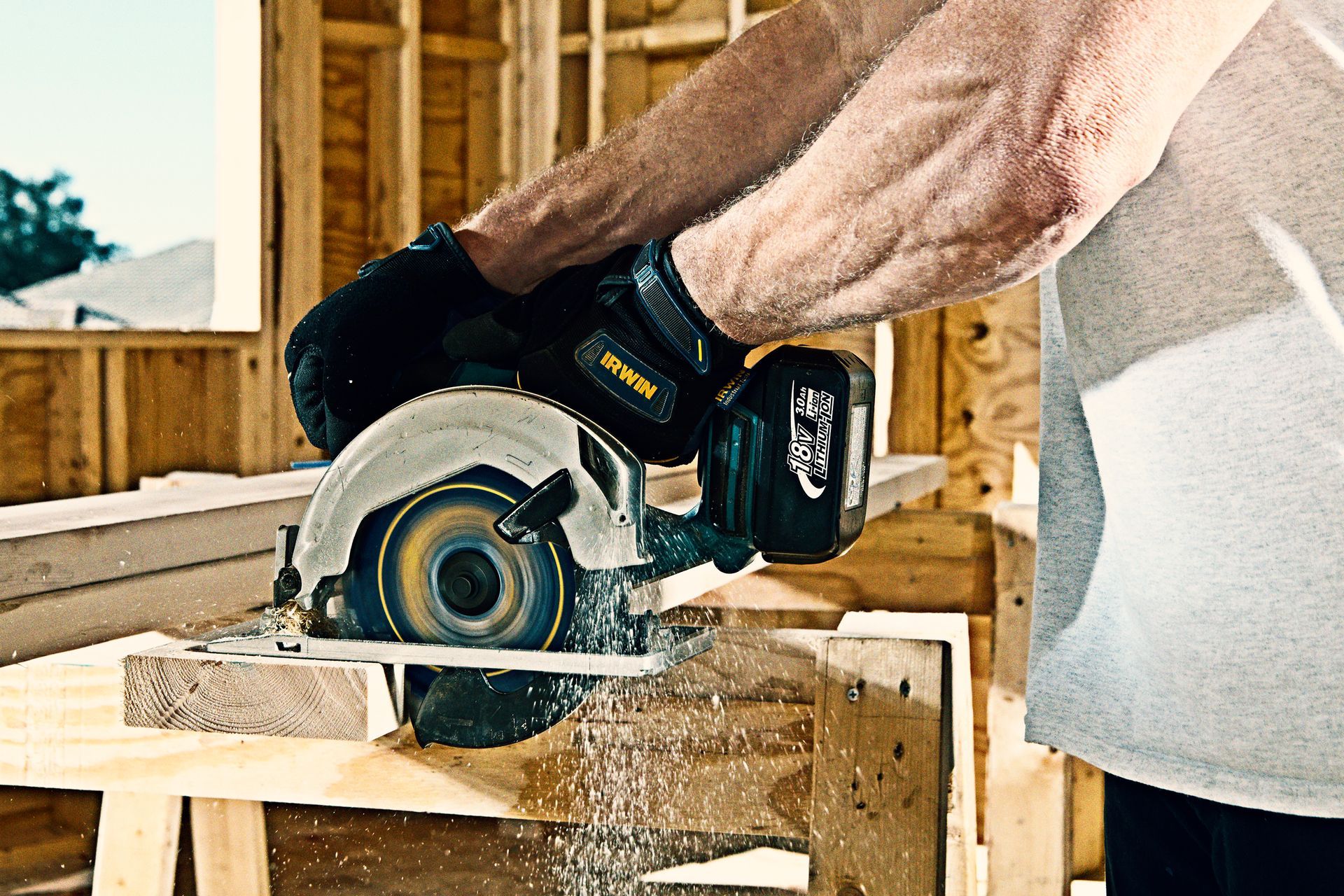 A man is using a Irwin circular saw to cut a piece of wood.