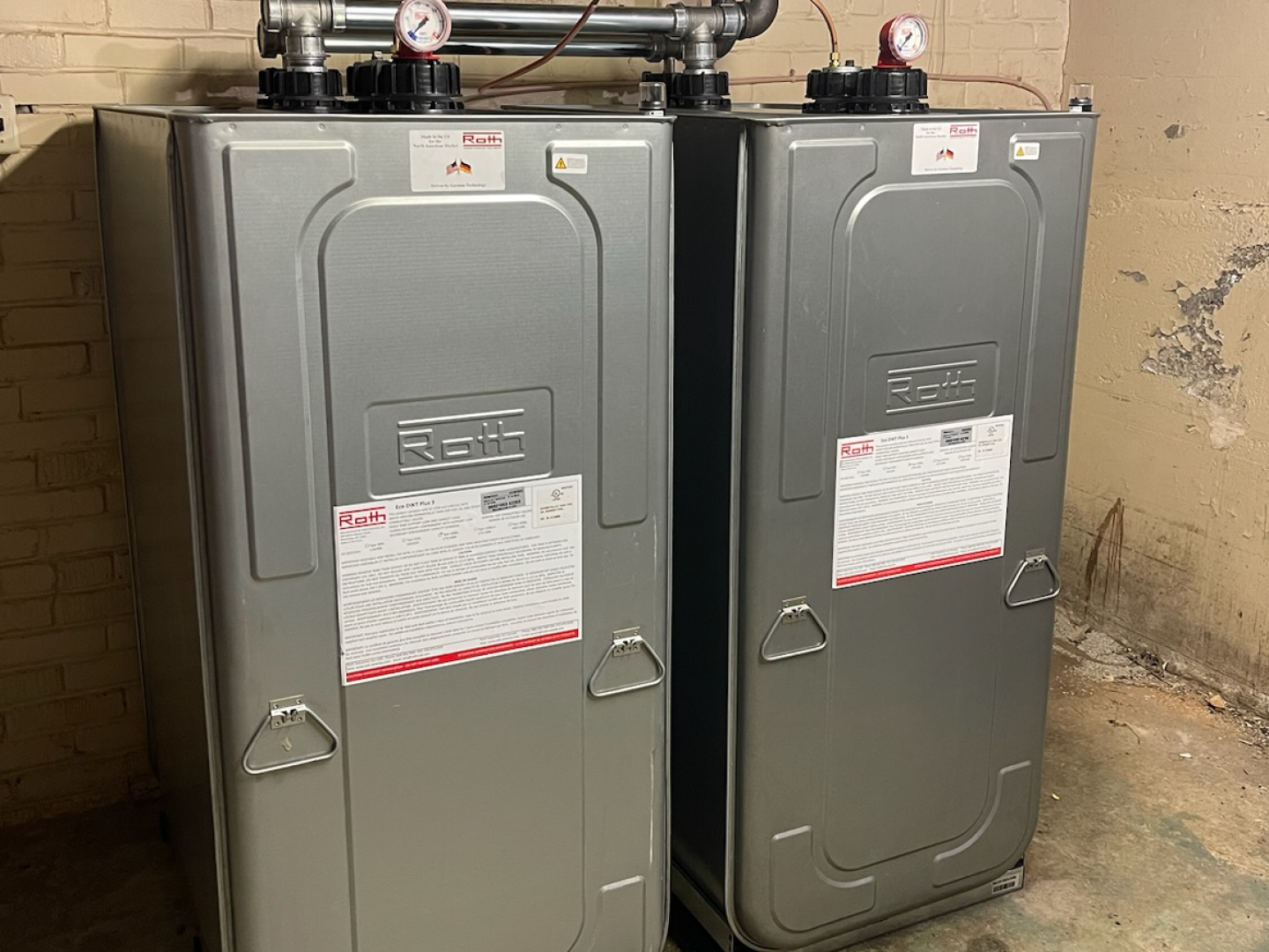 Two metal tanks are sitting next to each other in a room.