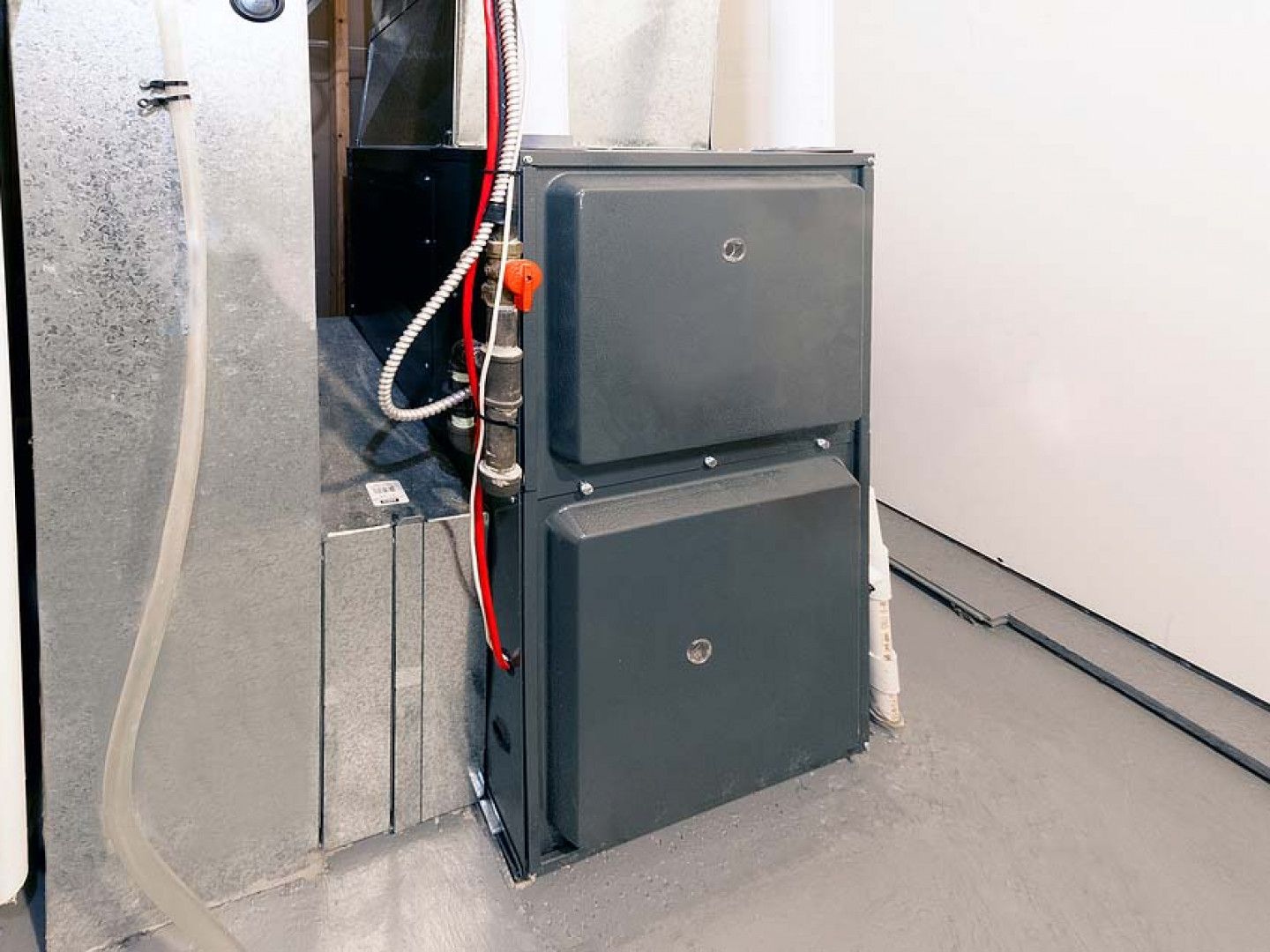 A furnace is sitting in a room next to a wall.