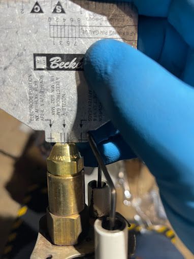 A person is measuring a brass pipe with a ruler.