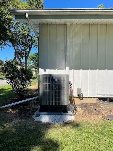 A large air conditioner is sitting on the side of a house.