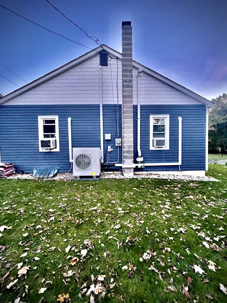 A blue and white house with a chimney on the side of it.