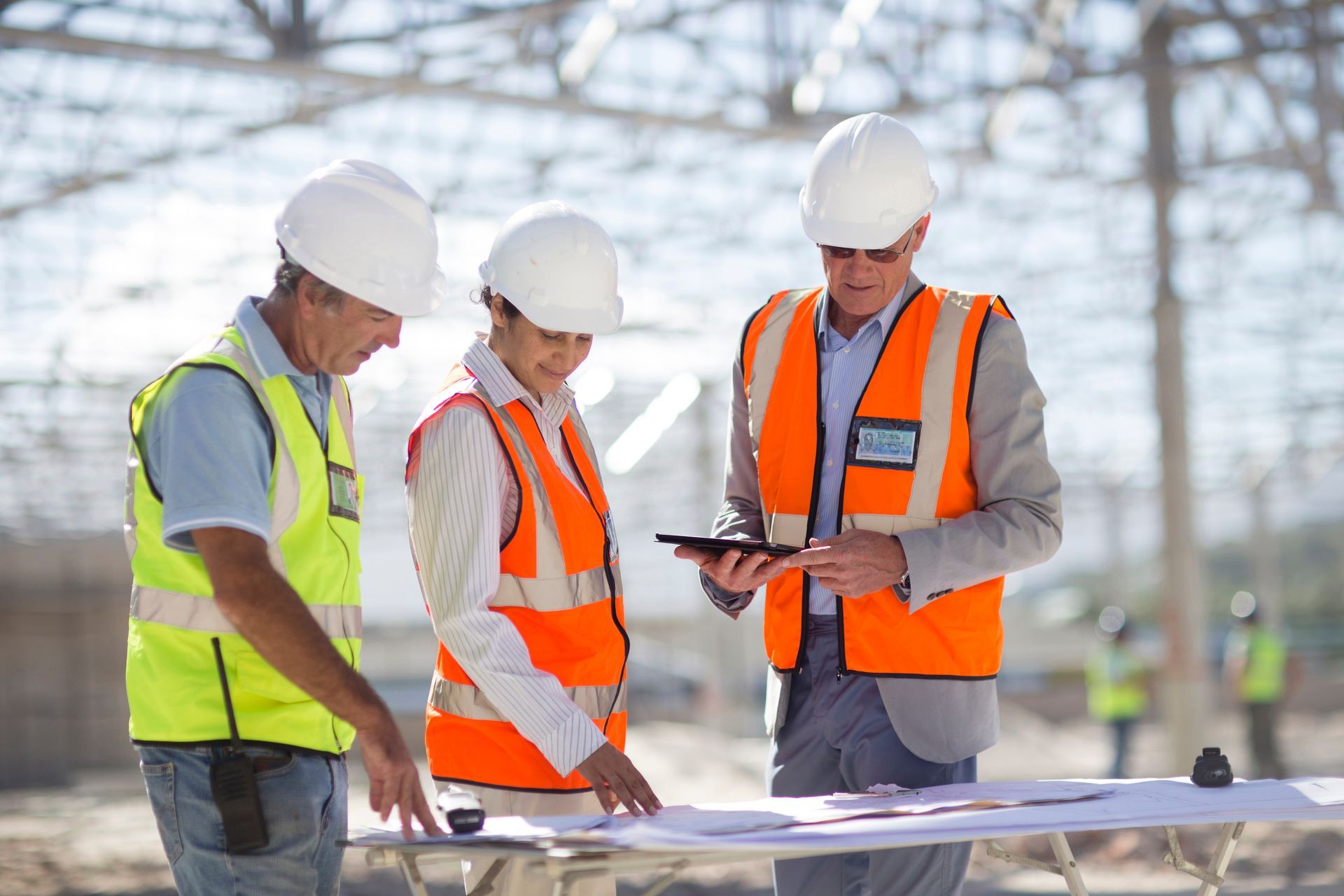 Construction professionals wearing hard hats and high-visibility vests.