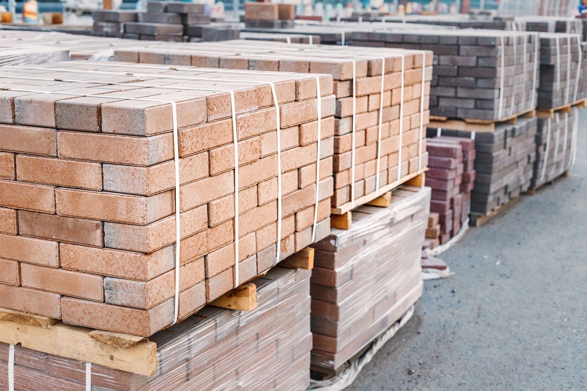 Stacks of red bricks wrapped on pallets in an outdoor строитель materials yard
