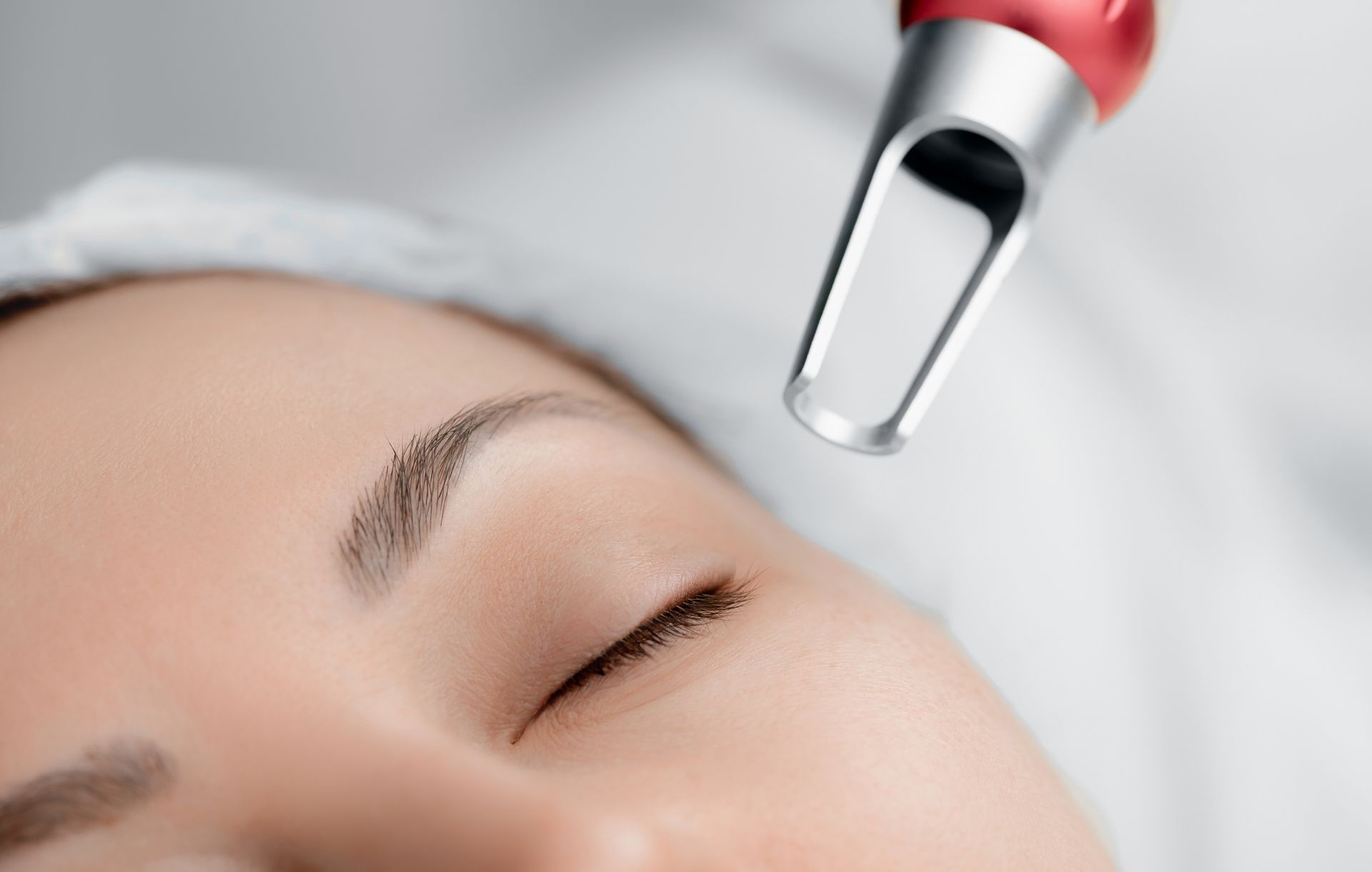A woman is getting a laser treatment on her face.