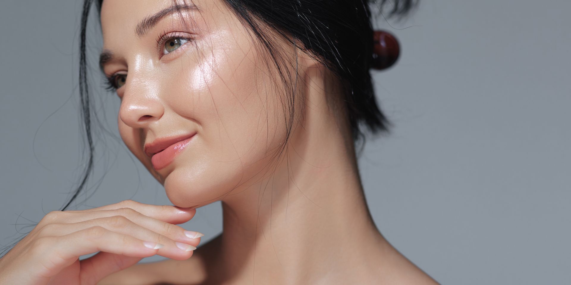 A close up of a woman 's face with a bun on her hair.