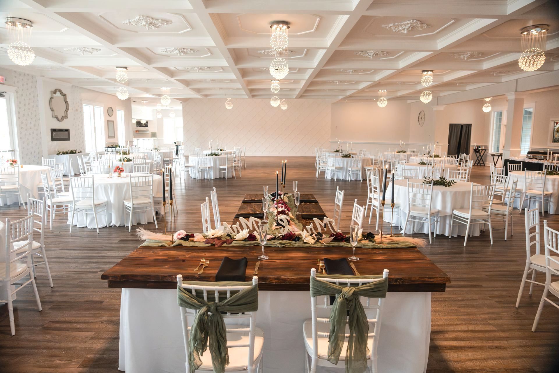 A large room with tables and chairs set up for a wedding reception.