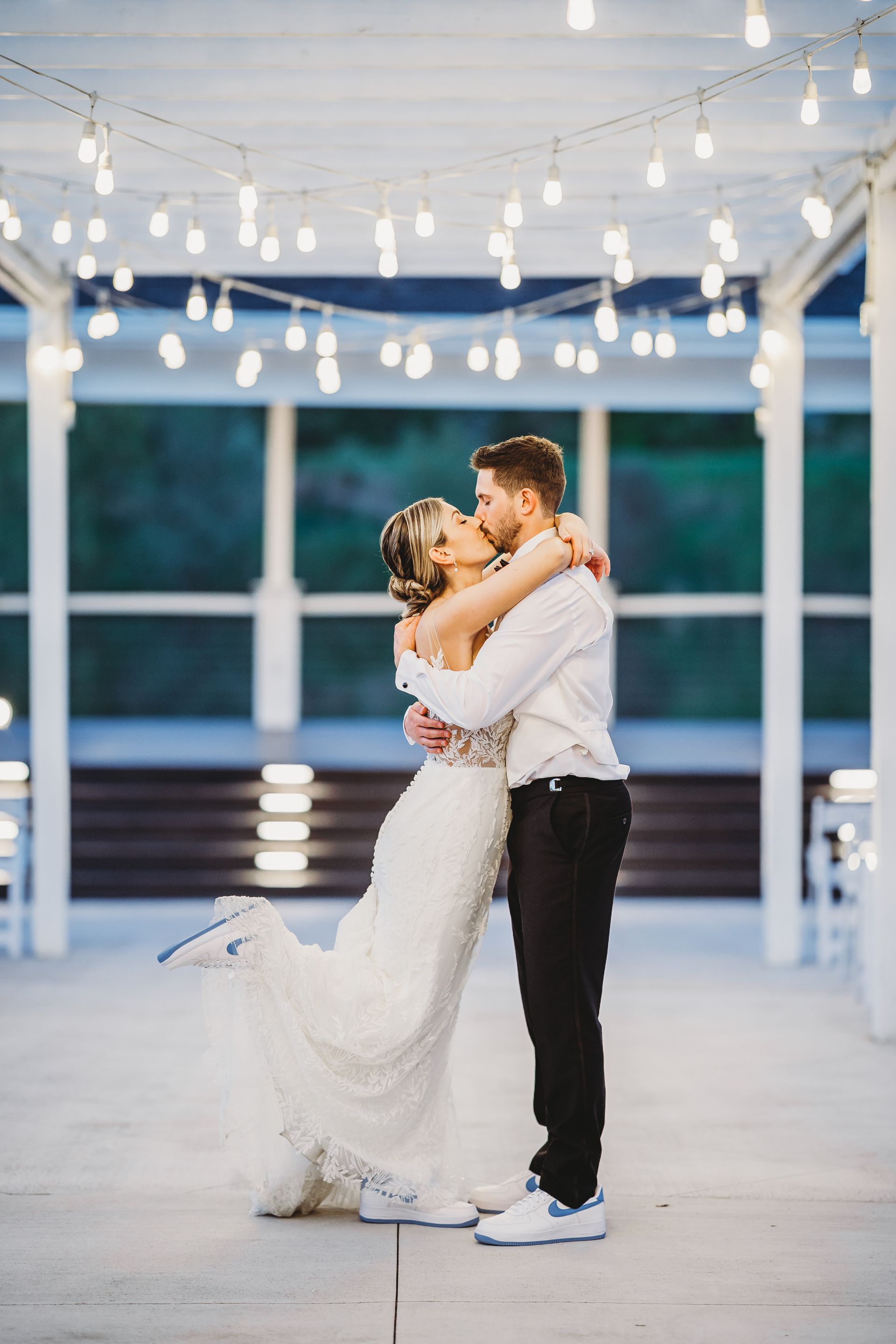 A bride and groom are posing for a picture in front of a fountain.