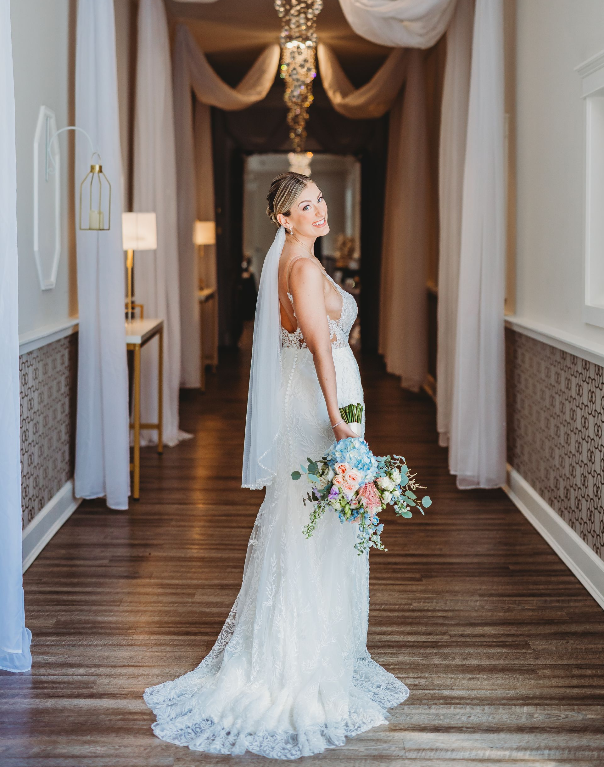 A bride and groom are kissing under a white archway.