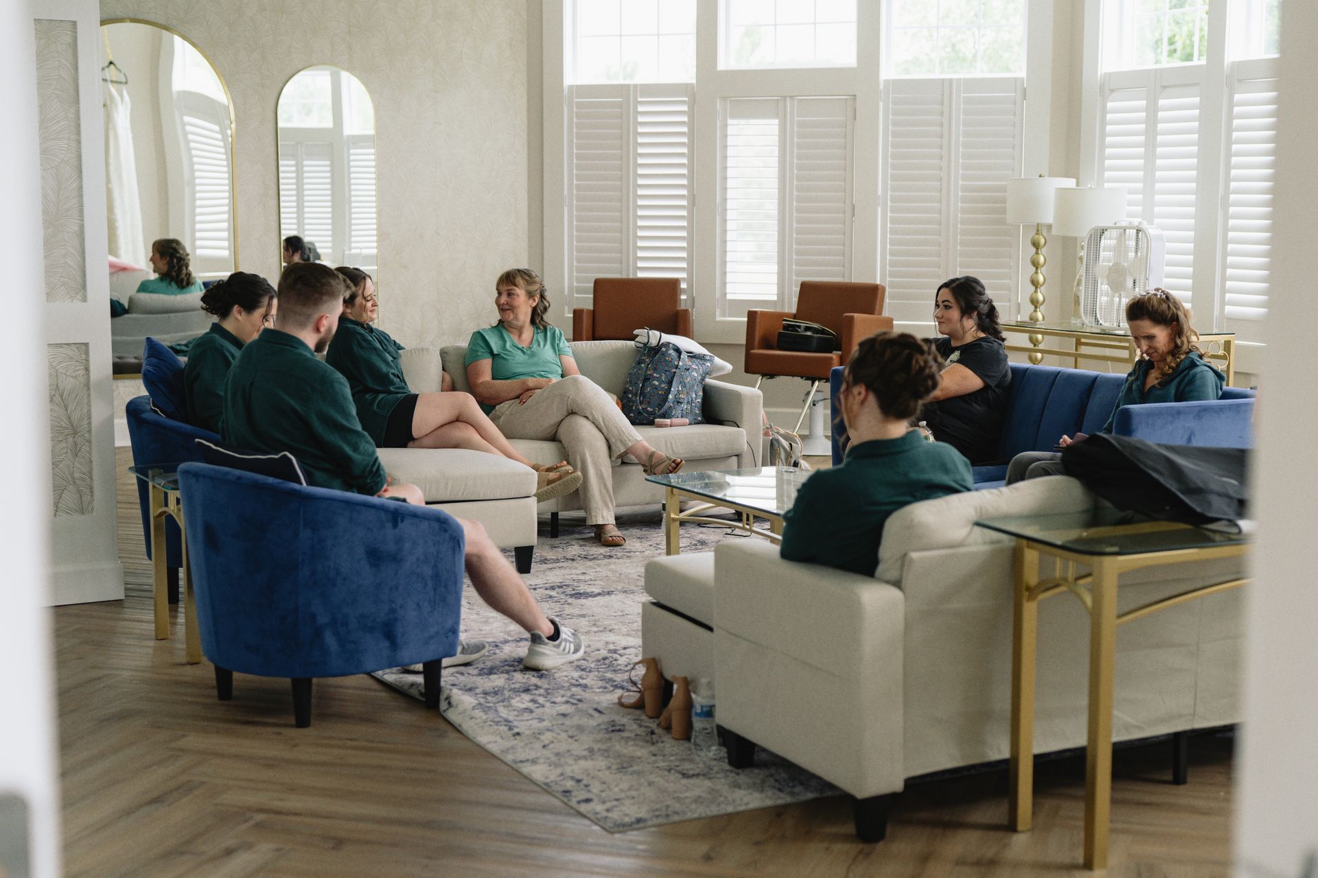 A group of people are sitting on couches and chairs in a living room.