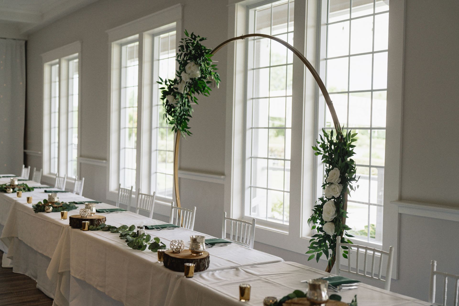 A long table is decorated with flowers and candles for a wedding reception.